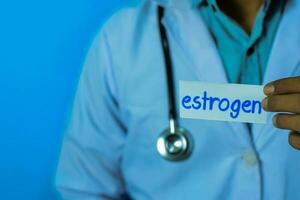 Doctor holding a card with text Estrogen. Medical and healthcare concept. photo