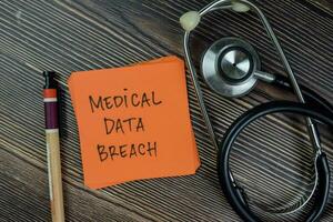 Concept of Medical Data Breach write on sticky notes isolated on Wooden Table. photo