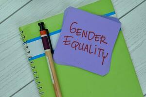 Concept of Gender Equality write on sticky notes isolated on Wooden Table. photo