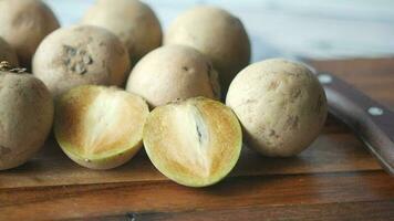 Sapodilla fruit on a chopping board on table video