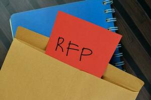 RFP - Request For Proposal write on sticky notes isolated on Wooden Table. photo