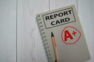 A plus - Report Card write on a book isolated on Office Desk. photo