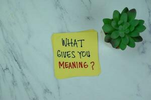 Concept of What Gives You Meaning write on sticky notes isolated on Wooden Table. photo