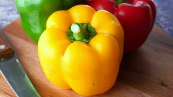 Yellow green and red capsicum on table, top view video