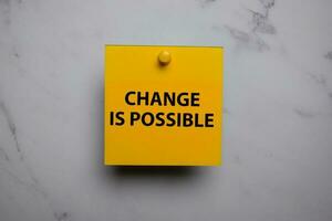 Change Is Possible write on sticky note isolated on Office Desk photo