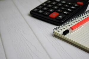 Calculator and a book isolated on office desk. Finance or business concept photo