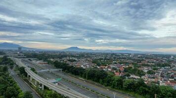 Aerial view of quiet traffic on Taman Mini street with mountain view during weekend in Jakarta city. Jakarta, Indonesia, March 8, 2022 photo