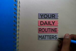 Your Daily Routine Matters. Handwriting on sticky notes on office desk photo