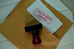 Red Handle Rubber Stamper and You've Been Served text isolated on the table. photo