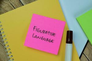 Concept of Figurative Language write on sticky notes isolated on Wooden Table. photo
