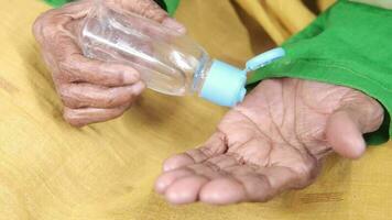 anziano donna mani utilizzando mano disinfettante gel, vicino su video