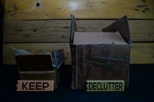 Keep and Declutter write on a sticky note between storage box isolated on wooden background. photo