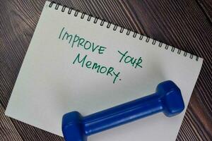 Improve Your Memory write on a book isolated on Wooden Table. photo