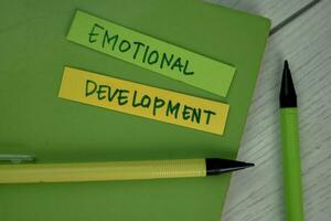 Emotional Development write on sticky notes isolated on Wooden Table. photo