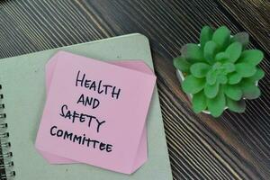 Health and Safety Committee write on sticky notes isolated on Wooden Table. photo