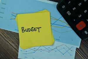 Concept of Budget write on sticky notes isolated on Wooden Table. photo