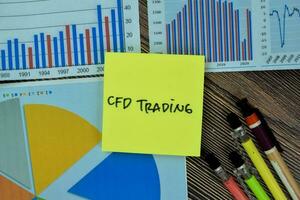 Concept of CFD Trading write on sticky notes isolated on Wooden Table. photo