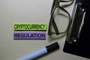 Cryptocurrency Regulation text on sticky notes isolated on office desk photo