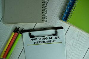 Investing After Retirement write on a paperwork isolated on wooden table. photo