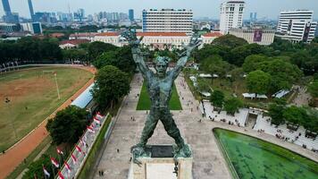 Aerial view of West Irian Liberation monument in downtown Jakarta with Jakarta cityscape. Jakarta, Indonesia, August 29, 2022 photo