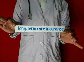 un médico de pie, sostener el a largo plazo cuidado seguro papel texto en rojo antecedentes. médico y cuidado de la salud concepto. foto