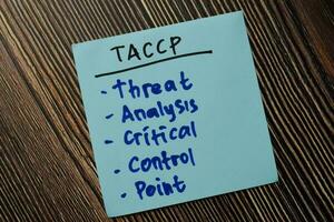 TACCP - Threat Analysis Critical Control Point write on sticky note isolated on Wooden Table. photo