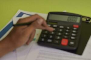 Blur and defocused calculate about cost and doing finance at home office. Business and Finance Concept photo