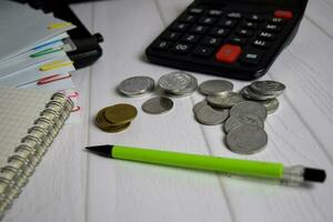 Calculator and the stack of coint isolated on office desk. calculating salary or tax concept photo