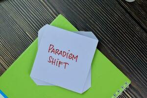 Paradigm Shift write on sticky notes isolated on Wooden Table. photo