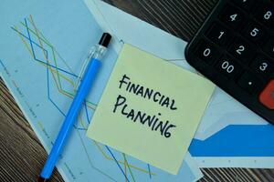 Concept of Financial Planning write on sticky notes isolated on Wooden Table. photo