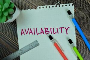 Concept of Availability write on sticky notes isolated on Wooden Table. photo