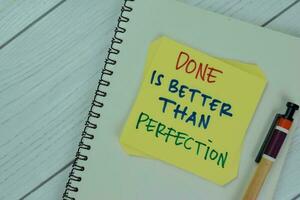 Concept of Done is Better Than Perfection write on sticky notes isolated on Wooden Table. photo