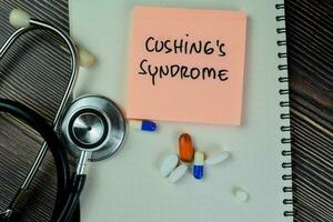 Concept of Cushing's Syndrome write on sticky notes with stethoscope isolated on Wooden Table. photo