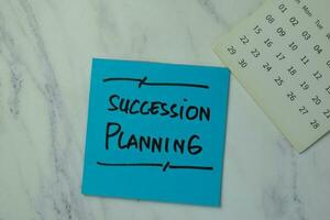 Succession Planning write on sticky notes isolated on office desk. photo