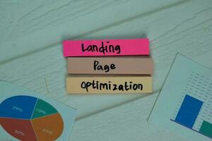Landing Page Optimization write on sticky notes isolated on office desk. photo