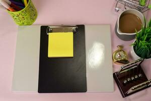 Top view of the notepad and clipboard with a marker drawing on a pink table, preparing to do homework. Drawing Working Desk Concept. photo