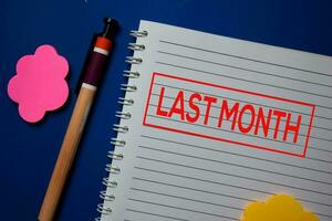 Last Month write on a book isolated on blue background. photo