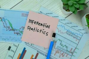 Concept of Inferential statistics write on sticky notes with statistics isolated on Wooden Table. photo