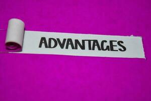 Advantages text, Inspiration and positive vibes concept on purple torn paper photo