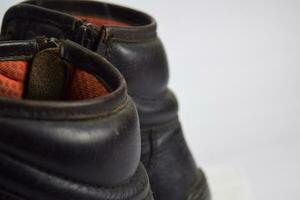 Close up of a brown old boots isolated on white background photo