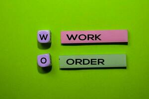 WO - Work Order acronym write on sticky notes isolated on Green background. photo