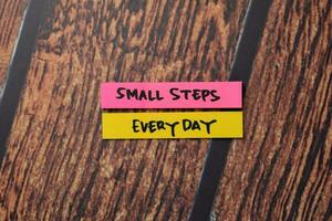 Small Steps Everyday write on sticky notes isolated on office desk. photo