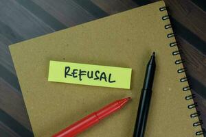 Refusal write on sticky notes isolated on Wooden Table. photo