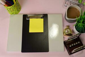 Top view of the notepad and clipboard with a marker drawing on a pink table, preparing to do homework. Drawing Working Desk Concept. photo