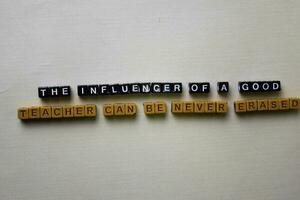 The Influencer of a Good Teacher Can be Never Erased on wooden blocks. Inspiration concept photo