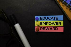 Educate, Empower, Reward text on sticky notes isolated on Black desk. Mechanism Strategy Concept photo