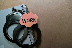 Work write on sticky note and Handcuffs isolated on Office Desk photo