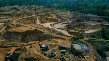 aéreo ver de trabajo de camiones y el excavador en un abierto pozo en oro minería. central sulawesi, Indonesia, marzo 3, 2022 foto