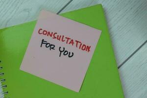 Concept of Consultation For You write on a book isolated on Wooden Table. photo