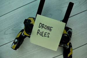 Drone Rules write on sticky notes isolated on Wooden Table. photo